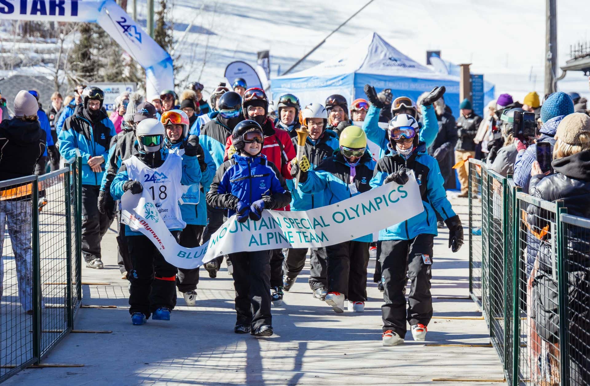 Special Olympians marching with banner during 24 Hour Blue Mountain fundraising event.