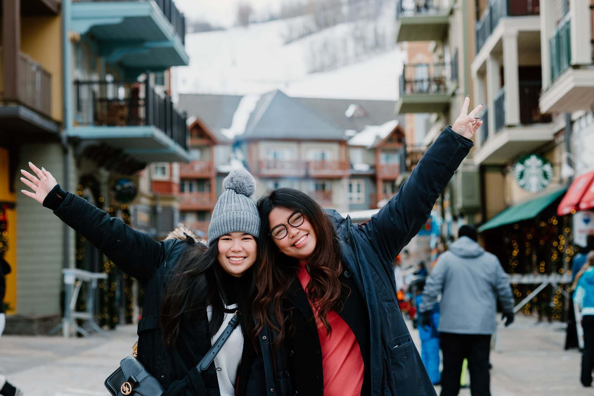 Two friends posing for a photo as they enter the village in the winter. 