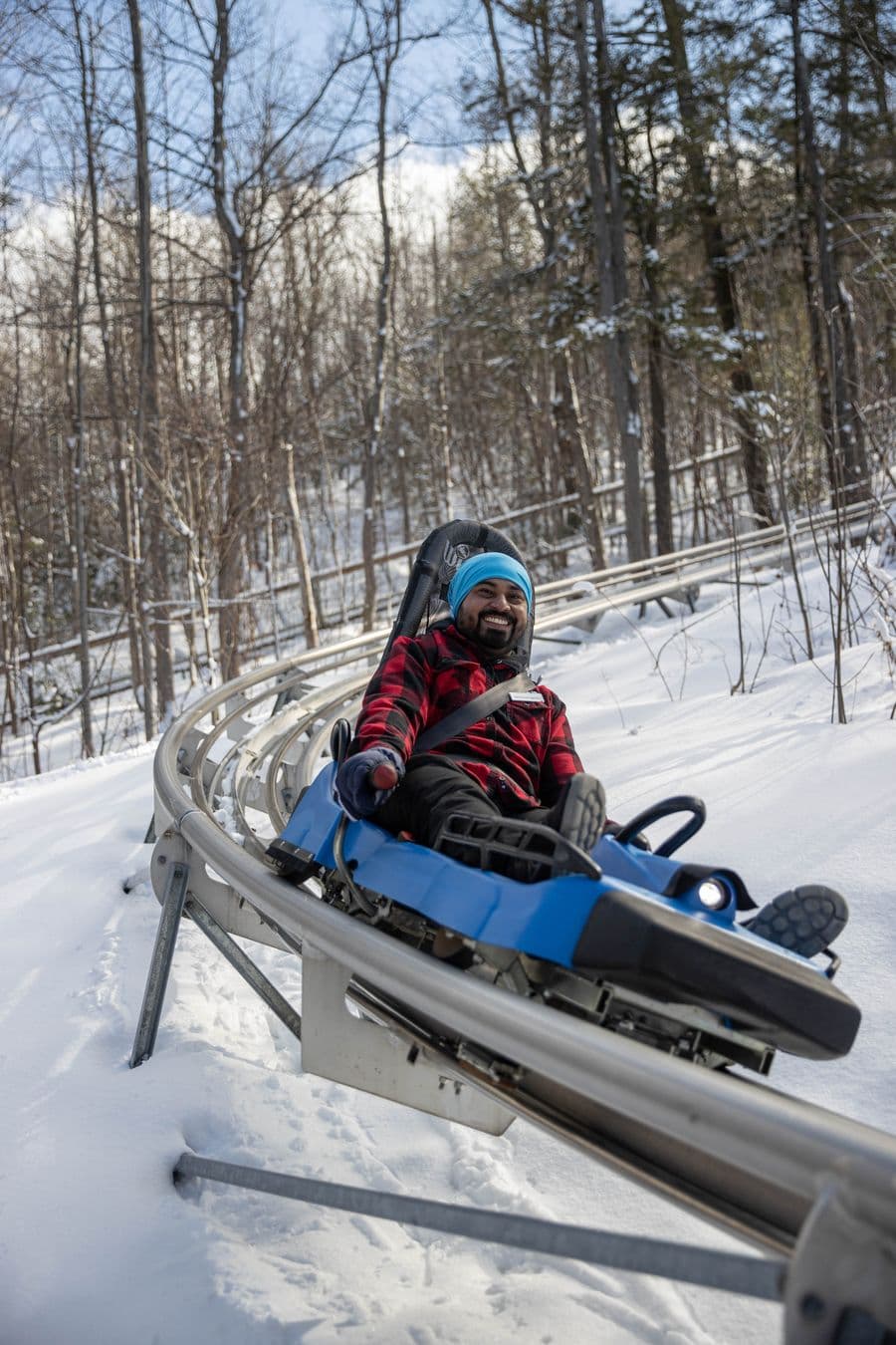 Man racing down the Ridge Runner Mountain Coaster on a Winter afternoon.