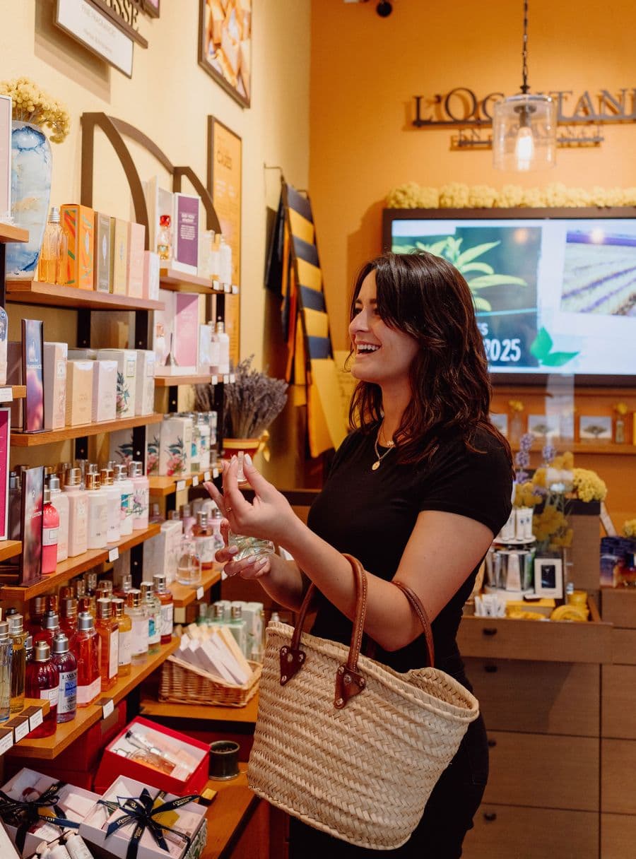 Woman shopping for high end skincare products inside L'Occitane En Provence.
