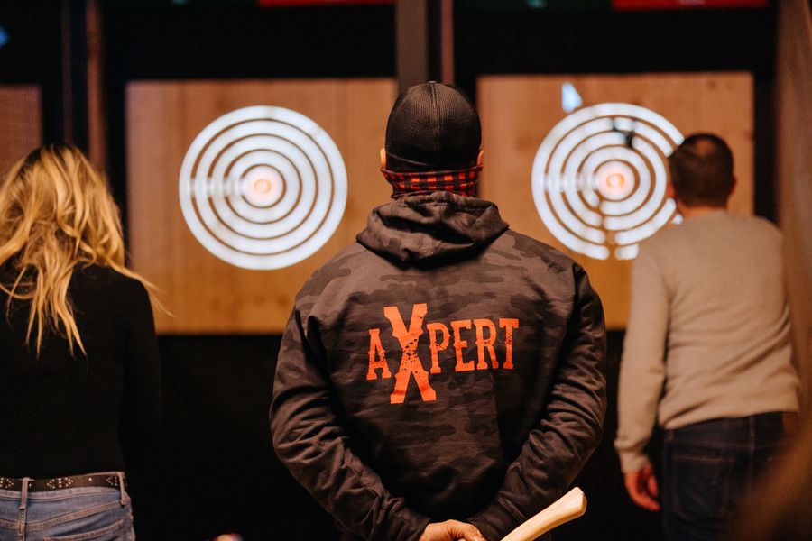 Axed Throwing "Axe-pert" assisting guests in their form so they can hit the bullseye.