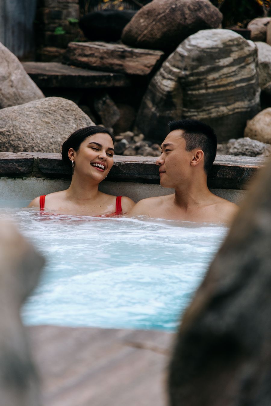 Couple laughing together as they relax in the outdoor hot tub at the Westin Trillium House.
