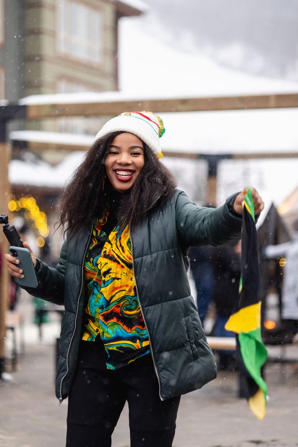 Woman dressed in Caribbean inspired colours, dancing in the Village events plaza.