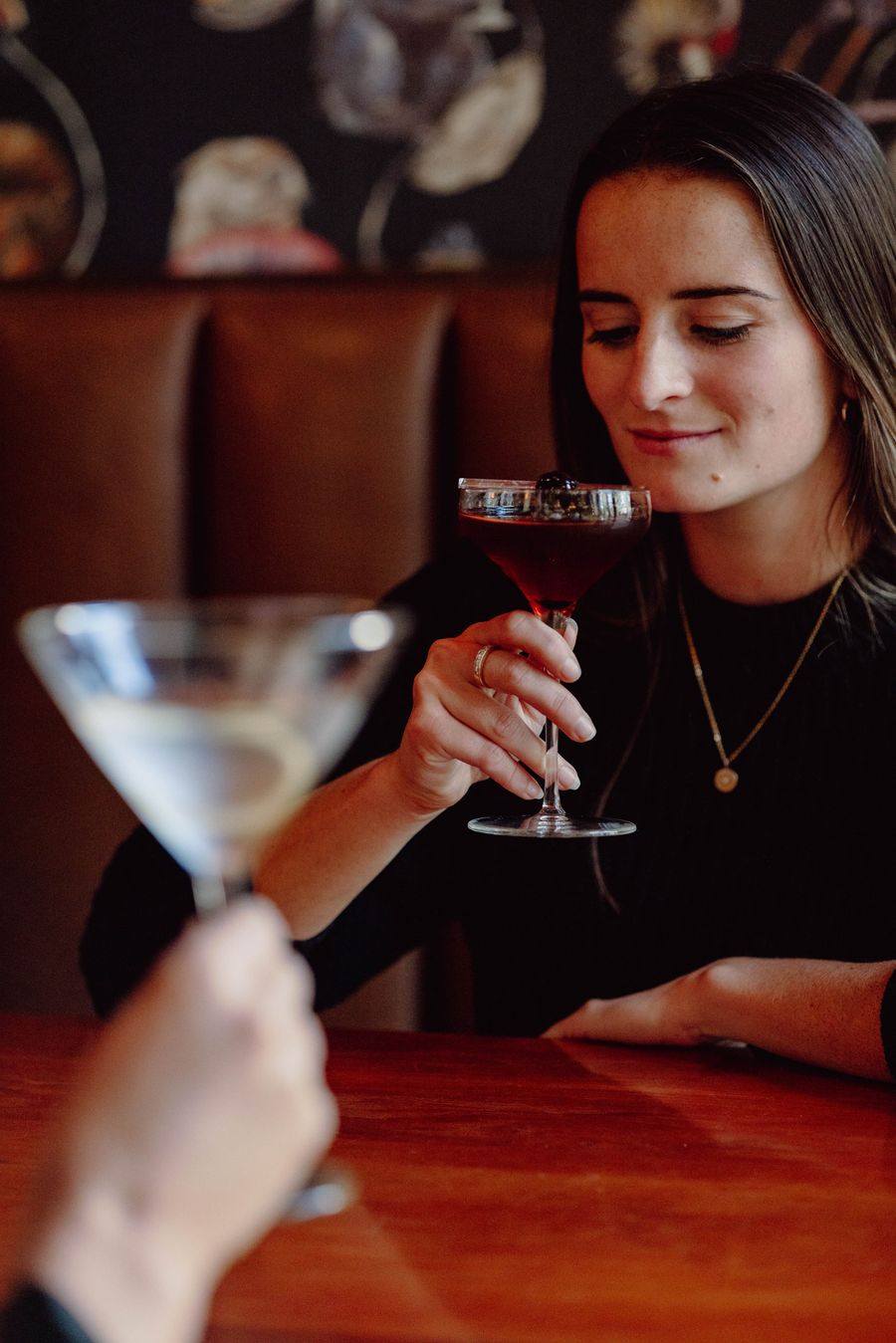 Woman and guest about to take a sip of specialty martinis from Twist Kitchen + Cocktail.